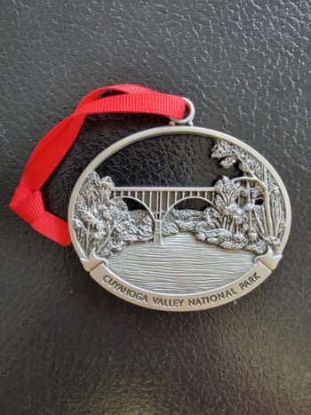 A metal ornament with a red ribbon featuring the words Cuyahoga Valley National Park.